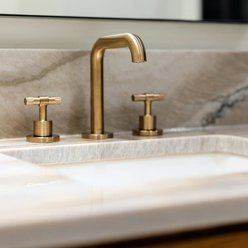 Brass faucet on a mitered quartzite vanity