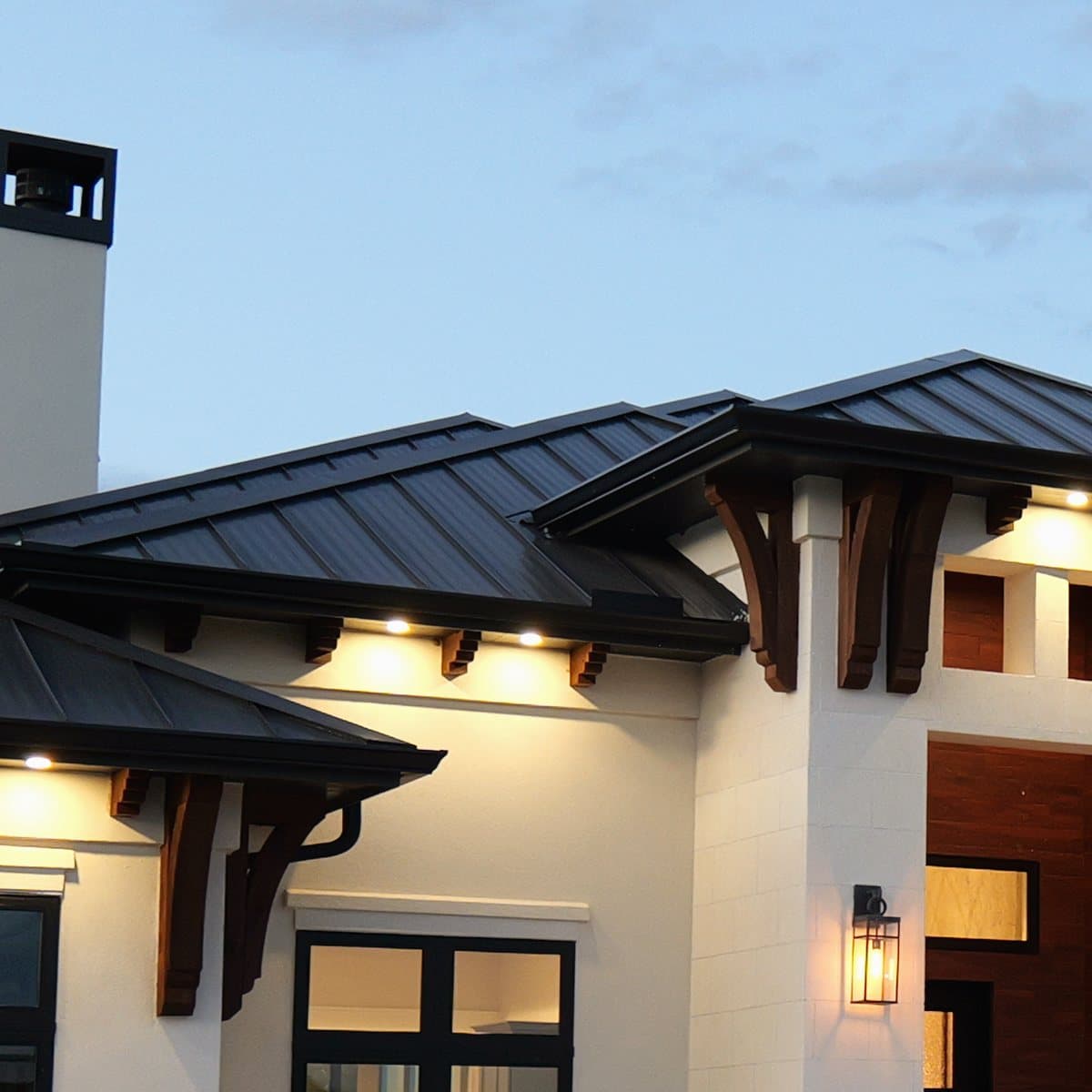 Cedar brackets under the eaves, lit at dusk