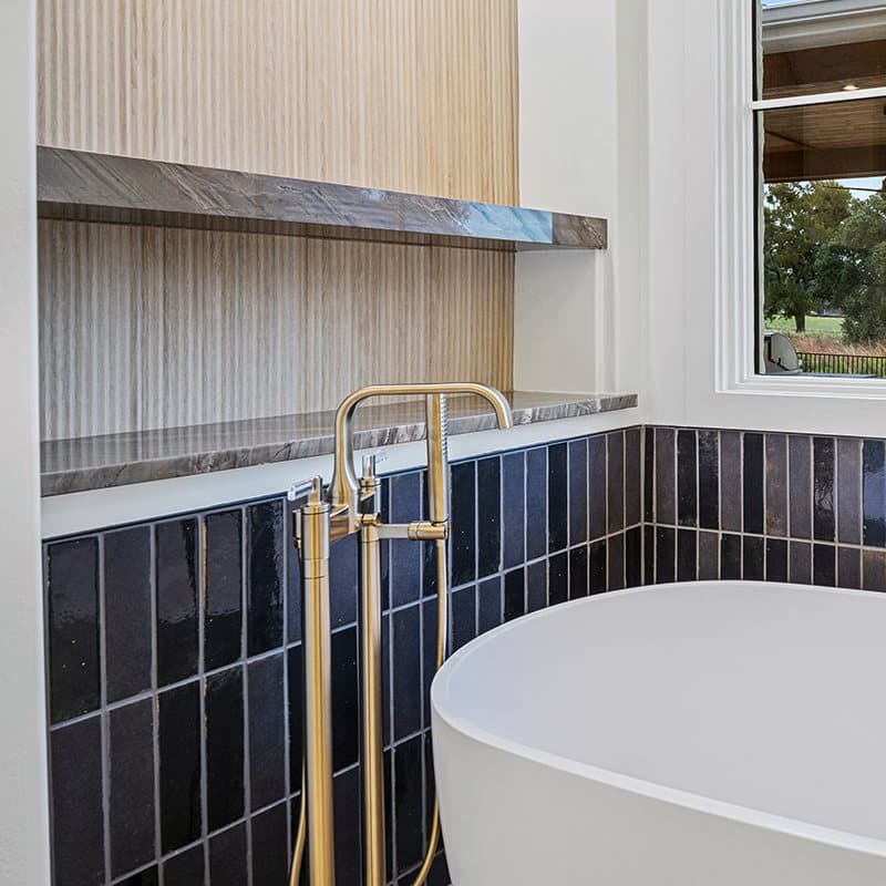 Fluted wood paneling above stacked black tile
