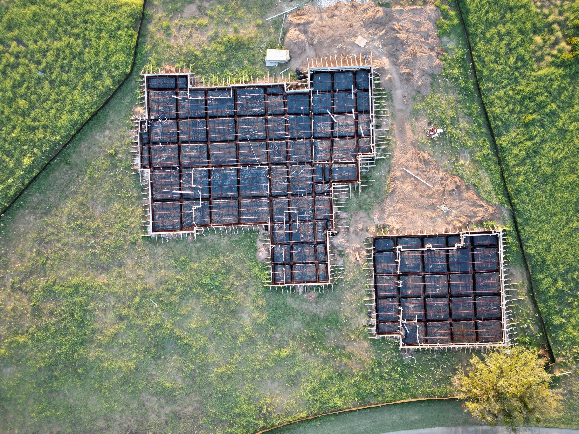 Aerial view of a foundation under construction, rebar and forms laid out on the site